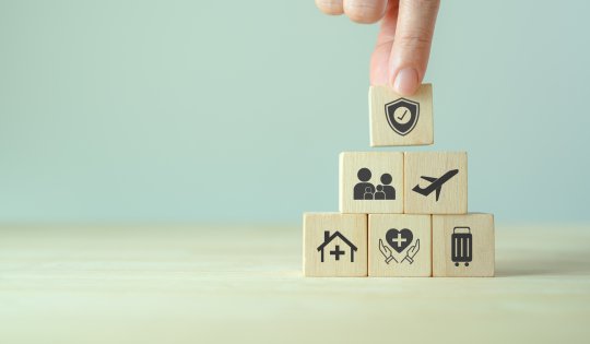 Travel safety and travel insurance concept. Wooden cubes with protect safety travel icon. Intended to cover medical expenses, trip cancellation, lost luggage and other losses incurred while traveling.